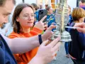 Eine Frau hält ein Handy, während eine Kerze das altenberger licht entzündet.