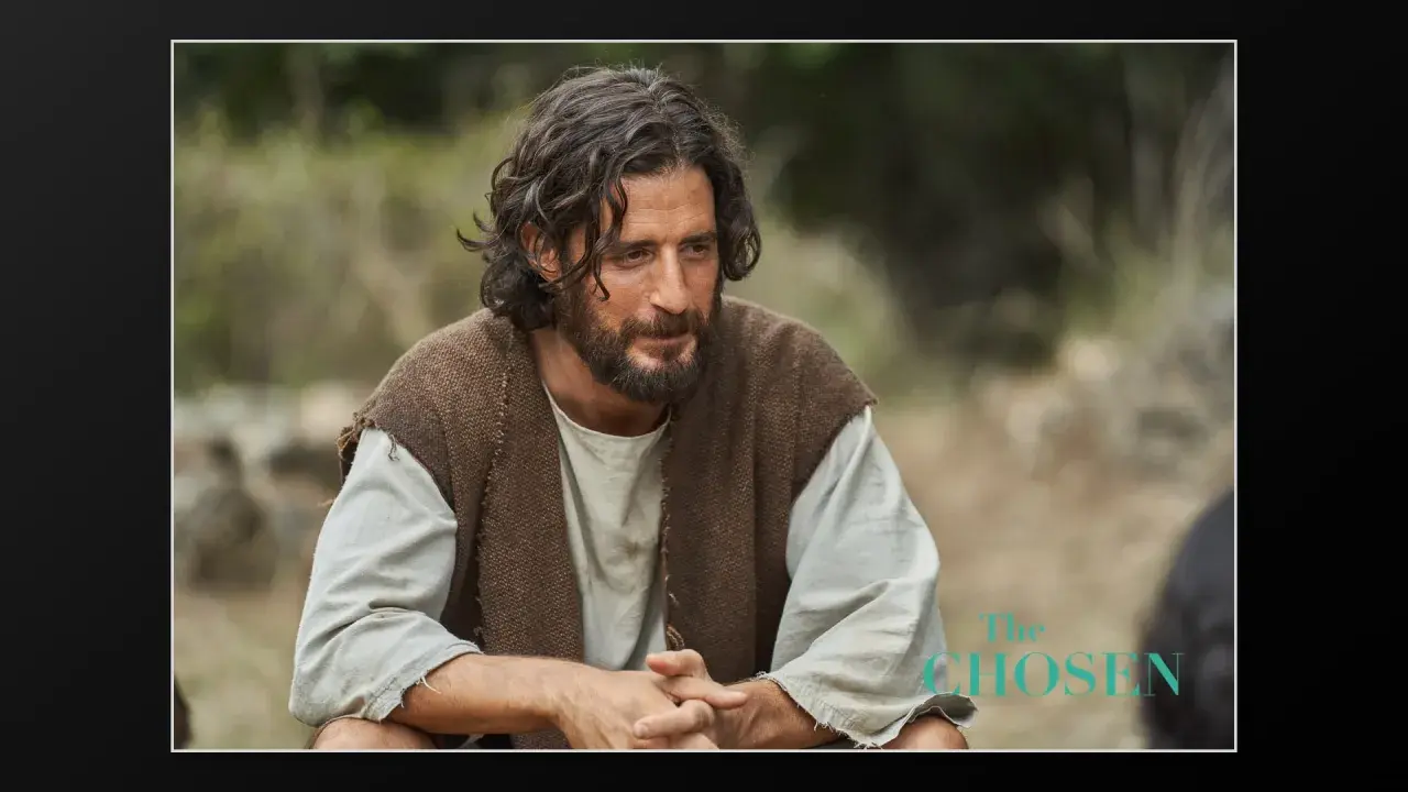 Jonathan Roumie als Jesus in "The Chosen", nachdenklich im Freien sitzend.